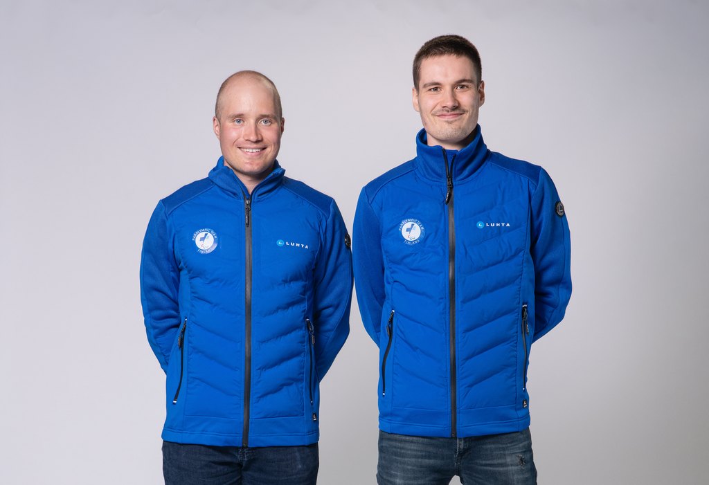 Inkki Inola ja Reetu Inkilä poseeraamassa kameralle sininen kisavarustus päällään, valkoista taustaa vasten.